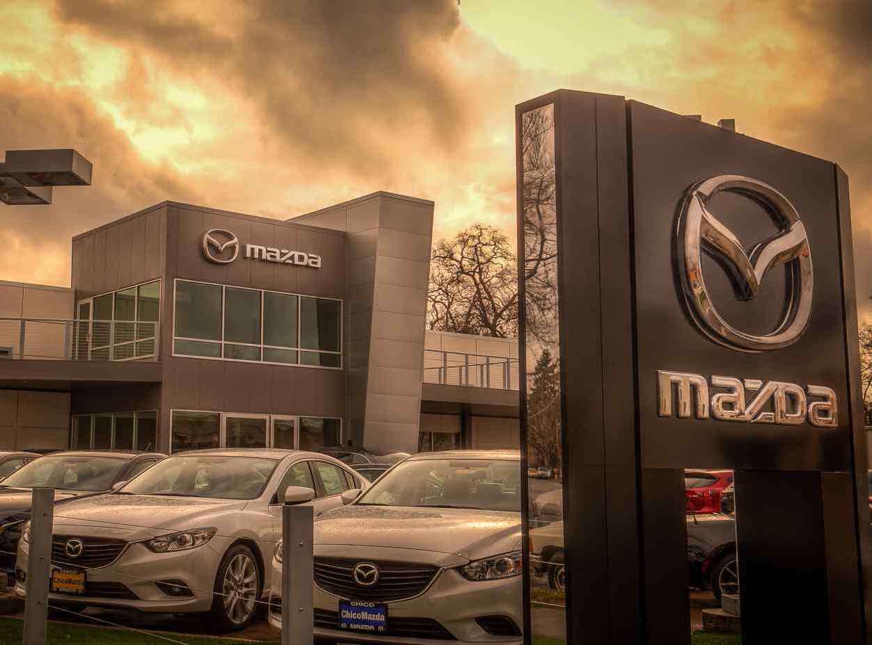 front view of a few new cars with Chico Mazda building in the background